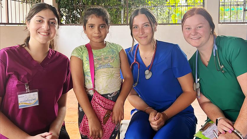 Image of Jenna Jedlicka, Kiana Salierno, and Abigail Oliveros with a patient in Costa Rica.